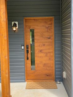 a wooden door sitting on the side of a gray house