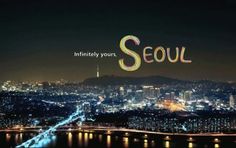 the words seoul are lit up at night in front of a large cityscape