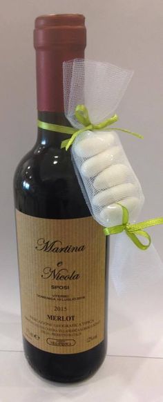 a bottle of wine is wrapped in a string and tied with a white mesh bow