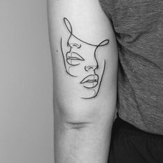 a woman's arm with a black and white line drawing of a mask on it