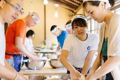 several people in a kitchen preparing food together