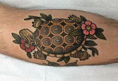 a man's arm with a turtle and flowers on it