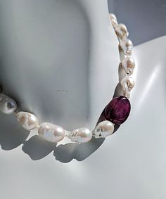 Introducing "Romancing the Stone" Pearl and Ruby Necklace crafted with love from my Oregon studio.Adorn yourself with the exquisite elegance of luxurious white baroque pearls. One smooth and tumbled large natural Ruby designed to be worn on the left shoulder. Small freshwater pearls are included and reveal themselves between each of the large pearls and ruby bead.The piece is secured with a 14 Karat gold hook and eye clasp, showcasing the artist's signature tag as a mark of authenticity and craftsmanship.The pearls, ranging from 12-16mm, boasts a luster that elevates the beauty of the necklace. Measuring 18.5" in length, this statement piece is sure to turn heads and leave a lasting impression wherever you go.For those who desire a complete ensemble, matching earrings are also available in Luxury White Baroque Pearl Necklace, White Baroque Pearl Necklace With Gemstone, White Briolette Pearl Necklace, White Baroque Pearl Necklace For Formal Occasions, Handmade White Baroque Pearl Necklace, Formal Handmade Baroque Pearl Necklace, Romancing The Stone, Glow Jewelry, Baroque Pearl Necklace