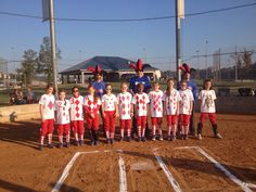 a group of young children standing next to each other on a baseball field