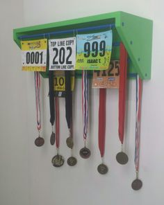 the medals are hanging on the wall in front of the numbered medal holder for each individual