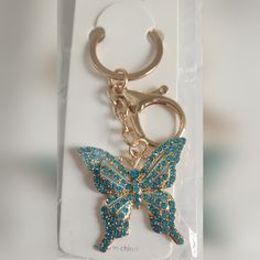 a keychain with a blue butterfly on it's side in a package