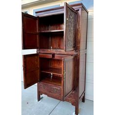 an old wooden cabinet is open on the sidewalk