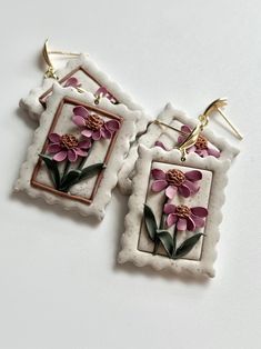 pair of earrings with pink flowers on white background