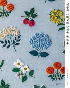 various flowers and leaves are embroidered onto the blue fabric with green leaves on each side