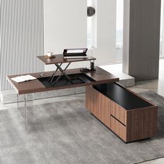 an office desk with a laptop on it and a drawer under the desk for storage