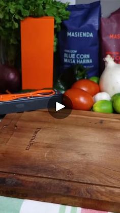 a cutting board with some vegetables on top of it and an orange bag in the background