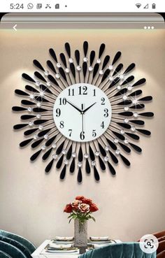 a clock that is on the wall above a dining room table with blue velvet chairs