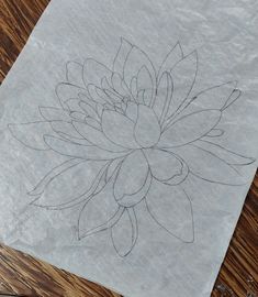 a piece of paper with a drawing of a flower on it sitting on a table