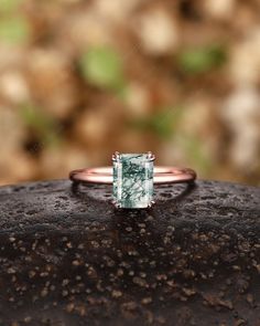 a ring with an aqua blue topazte in the center on a stone surface