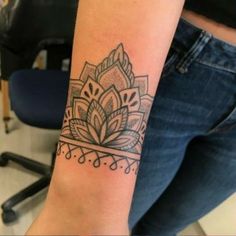 a woman's arm with a tattoo on the wrist and an intricate flower design