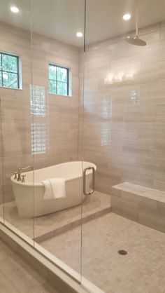 a bathroom with a tub, sink and shower in it's glass walled area