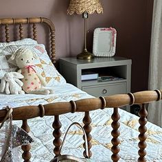 a bed with a wooden headboard and foot board next to a lamp on a night stand