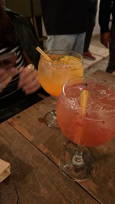 two cocktails sitting on top of a wooden table