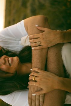 a woman is laying down with her hands on the man's back while he smiles