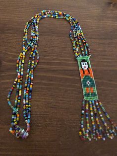 Very nice old necklace, probably Native but I can't be certain. Lovely rainbow of colored seed beads, snap closure, female beaded image with rainbow beaded fringe. 17 inches long with fringe. Traditional Multicolor Beaded Necklaces With Fringe, Traditional Multicolor Beaded Fringe Necklaces, Traditional Multicolor Beaded Necklace With Fringe, Artisan Multicolor Beads With Beaded Fringe, Artisan Multicolor Beaded Fringe, Artisan Multicolor Beaded Necklaces With Fringe, Artisan Multicolor Beaded Necklace With Fringe, Multicolor Beads With Beaded Fringe For Jewelry Making, Multicolor Beaded Fringe Necklaces As Gift