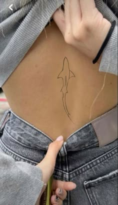 a woman's stomach with a small tattoo on it