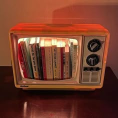 an old fashioned television with books in it