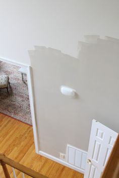 an open door leading to a living room with hard wood flooring and white walls