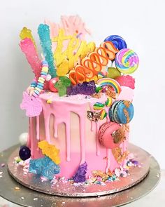 a pink cake with candy and candies on it