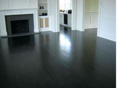 an empty living room with wood flooring and white painted walls, along with built - in fireplaces