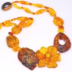 Necklace Stone(s): genuine Baltic honey amber and genuine wood Necklace Length: 19 inches Deep: 1.75 inches Weight: 66.3 grams Clasp: Toggle Stamp/Mark: N/A Origin: Poland Serial Number: n20692 Amber, an organic gemstone, is the fossilized sap of prehistoric trees which grew up to 50 million years ago. The stone has been used for jewelry since the time of Christ. The world's finest amber comes from the region around the Baltic sea. This is a DESIGNER, one-of-a-kind genuine Baltic Amber 5, hand-m Luxury Gold Necklace With Baltic Amber, Luxury Amber Gemstone Necklace, Prehistoric Trees, Amber Bead Necklace, Flower Carving, Special Flowers, Necklace Stone, 50 Million, Wood Necklace