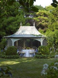 a white gazebo sitting on top of a lush green field