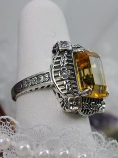 Natural Lemon-Yellow Citrine Sterling Silver RingPicture Frame Design#D227 Inspired by Victorian era designs, this is a lovely reproduction ring. This lovely filigree ring is handcrafted sterling silver. This gorgeous ring is set with a natural yellow citrine, which has a great shine and very good clarity. The emerald cut natural citrine gemstone is 12mm x 10mm. The ring measures 18mm North to South and 15mm East to West on the finger. The inside of the band is marked 925 for silver. Notice the Vintage Sterling Silver Topaz Collectible Ring, Vintage Sterling Silver Topaz Ring For Gift, Vintage Hallmarked Topaz Ring In Sterling Silver, Vintage Sterling Silver Topaz Ring, Sterling Silver Intaglio Wedding Ring, Ornate Intaglio Rings For Anniversary, Handmade Victorian Sterling Silver Filigree Ring, Vintage Sterling Silver Intaglio Ring, Vintage Engraved Topaz Ring Gift