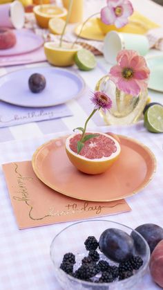 a table topped with plates and bowls filled with fruit