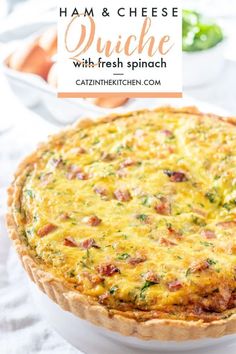 ham and cheese quiche with fresh spinach in a white dish on a table