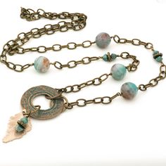 This turquoise Agate necklace features beautiful faceted light turquoise blue with brown veining Agate gemstones with vintage accent beads along with a unique brass verdigris pendant with a copper leaf charm. The antique brass etched cable chain in this long boho necklace is made of high quality brass and can easily be slipped on/off over your head, therefore no need for a clasp. For an effortlessly chic look wear this one-of-a-kind gemstone beaded necklace alone or layered with other boho style Bohemian Turquoise Pendant Necklace With Patina, Spiritual Patina Copper Necklace, Bohemian Agate Necklace In Bronze, Bohemian Copper Necklace With Patina, Bohemian Bronze Agate Necklace, Bronze Agate Bohemian Necklace, Bohemian Brass Necklace With Patina, Bohemian Patina Bronze Necklace, Bohemian Chrysocolla Necklace With Patina