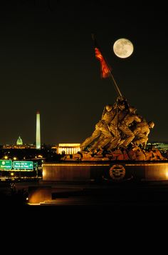 the statue is lit up at night in front of the washington monument