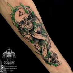 a skull and snake tattoo on the arm