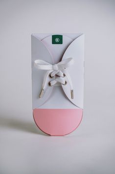 a white and pink shoe box with a bow on the top, inside it is an empty card board