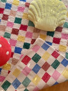 a red object is sitting on the floor next to a colorful towel and other items