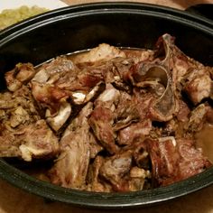 a bowl filled with meat sitting on top of a table