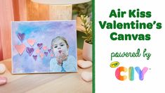 an air kiss valentine's canvas is displayed on a table