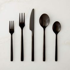 five forks, two spoons and one knife on a white surface