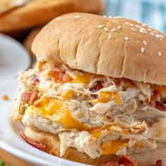 a chicken salad sandwich on a plate with lettuce and tomato slices next to it