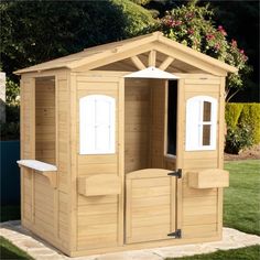 a small wooden shed sitting in the grass