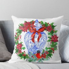 a blue and white vase filled with poinsettis on top of a couch