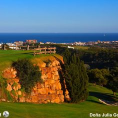 a golf course with the ocean in the background