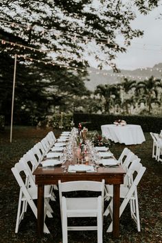 a long table set up with white chairs