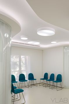 an empty meeting room with blue chairs and white walls