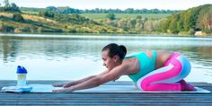 a woman is doing yoga on a dock by the water with an inflatable object