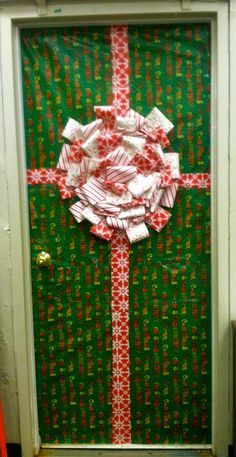 a green door decorated with red and white wrapping